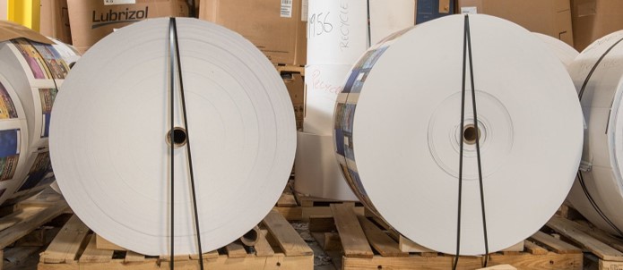 Two large bundles of printed rollstock film ready for use in packaging applications.